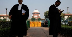 a lawyer looks into his mobile phone as another walks past in front of india s supreme court in new delhi december 11 2023 reuters adnan abidi